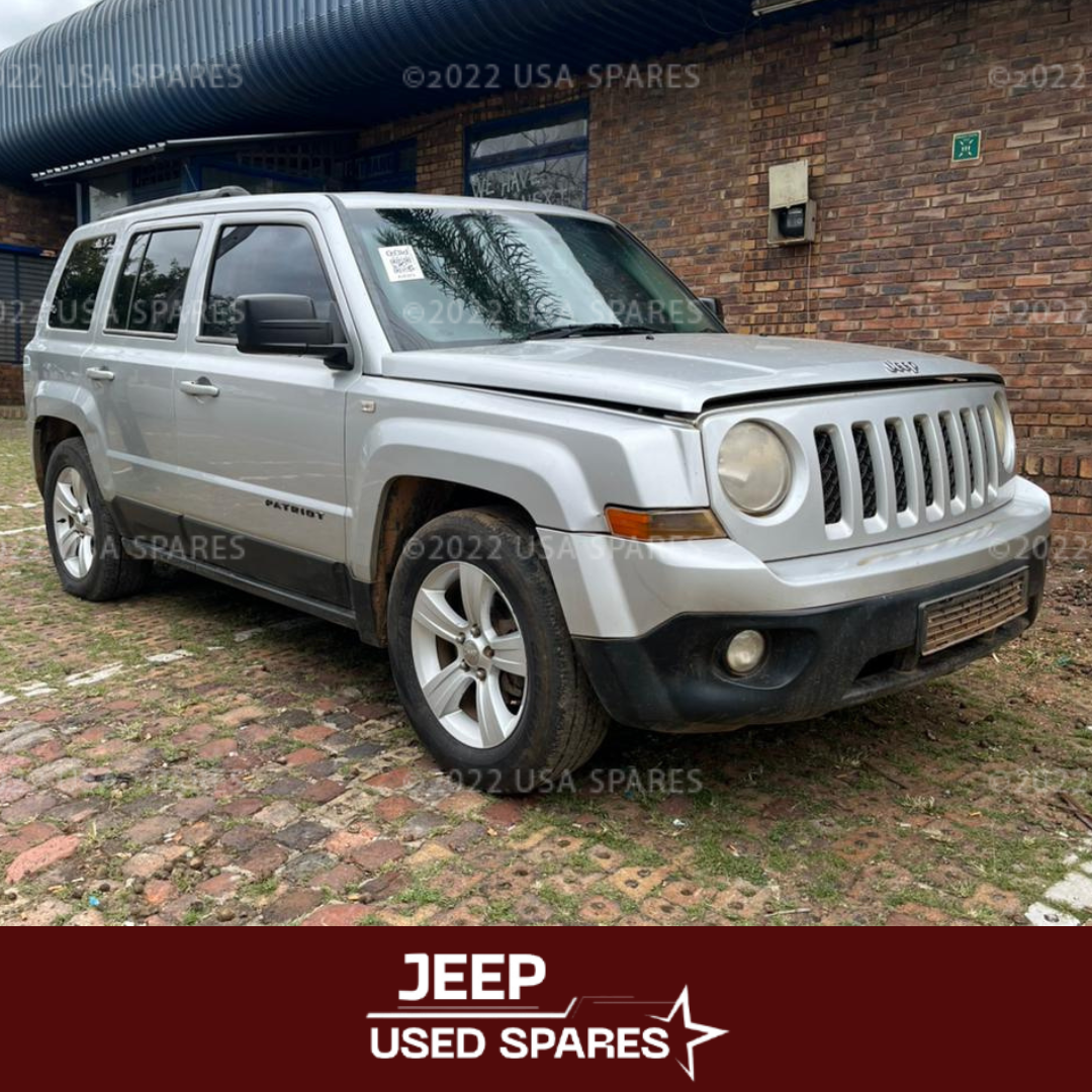 2014 Jeep Patriot 2.4 being stripped for spares with engine, transmission, suspension, body panels, interior parts, and electrical components removed and prepared for resale and vehicle repairs.
