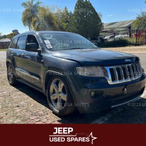 Image of 2013 Jeep Grand Cherokee 5.7 WK2 Automatic Petrol stripping for spares, showing dismantled vehicle components including engine parts, suspension, body panels, and interior items available for resale.